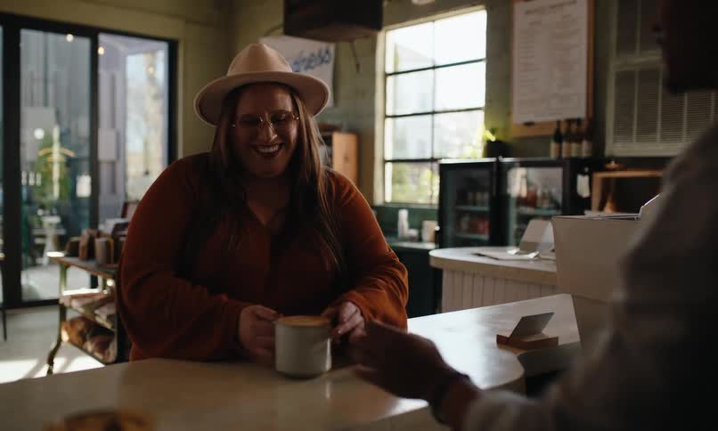 A woman picks up a coffee in a cafe