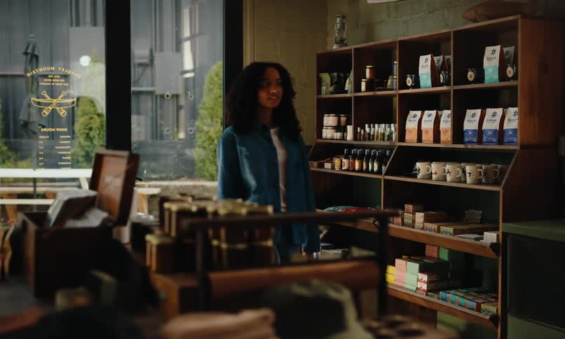 Curly haired woman walking into a coffee shop