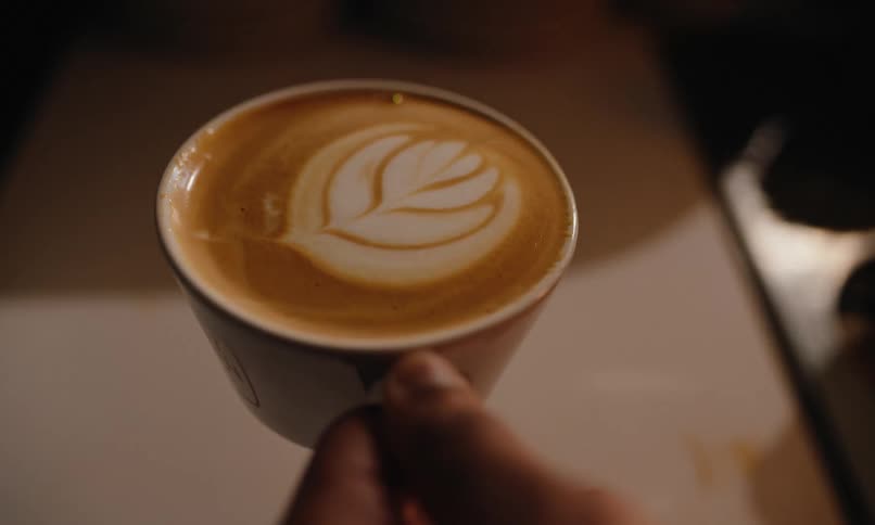 A person picks up a cappuccino