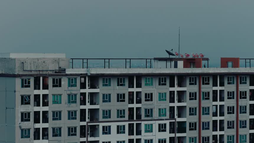 An apartment building has a railing around the entire roof