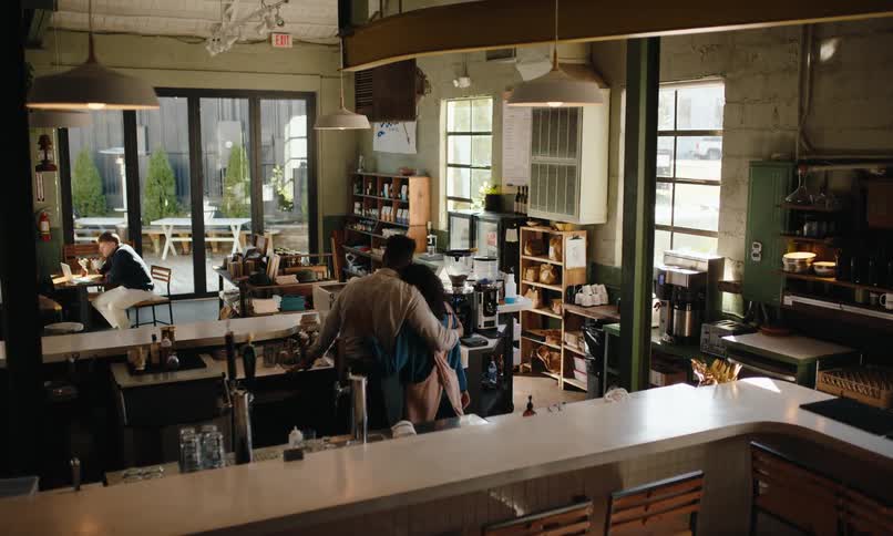 A footage of a man and a couple sharing a hug in the coffee shop