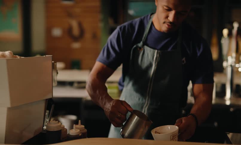 Male barista works behind the counter in a coffee shop