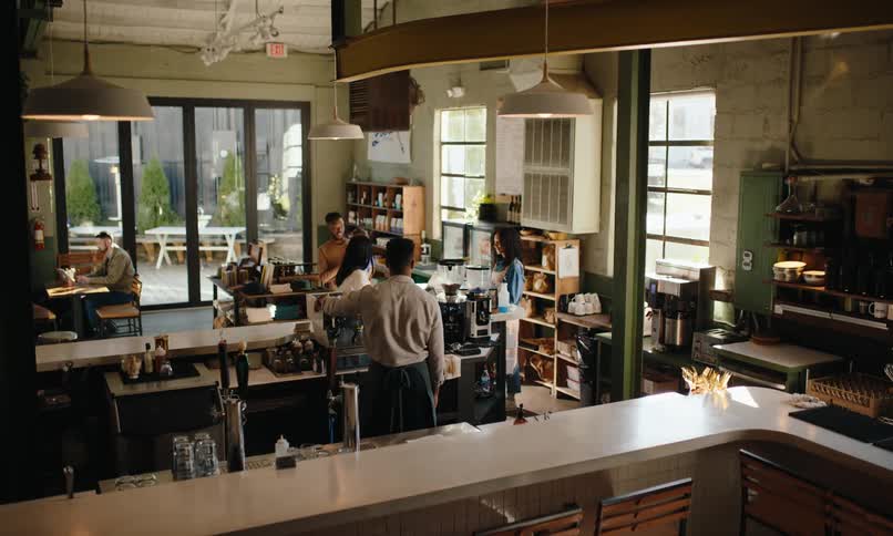Family entering a coffee shop and being served by employees
