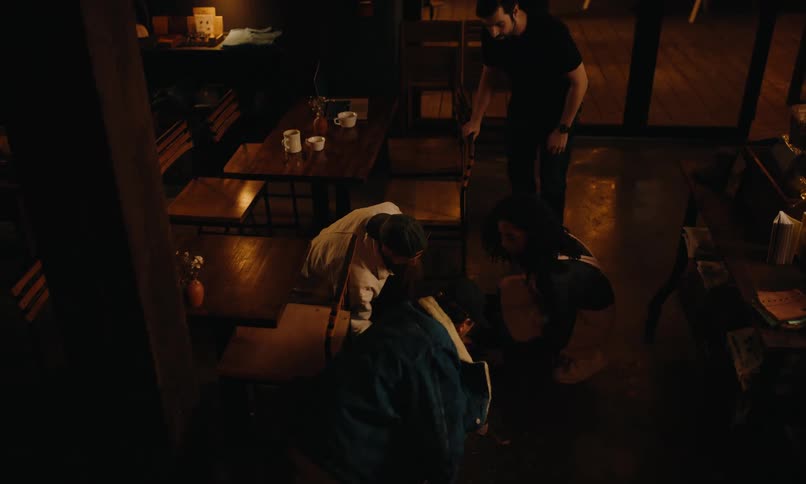 A waitress has dropped a tray of food and a customer helps her clean it up