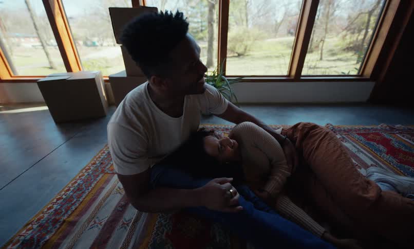 A footage of a couple sitting on a mat indoor