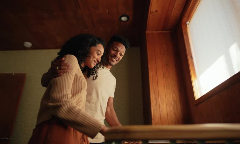 A couple looks down into a crib in a room