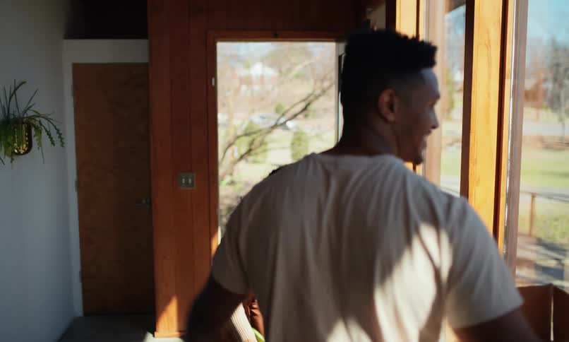 A man and woman set down their boxes and embrace celebrating their move into a modern home