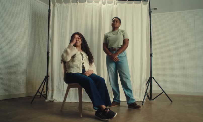 Two women are modeling with a spotlight above