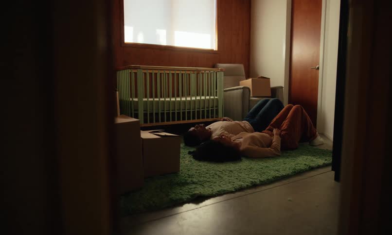 A man and woman are laying on the carpet talking