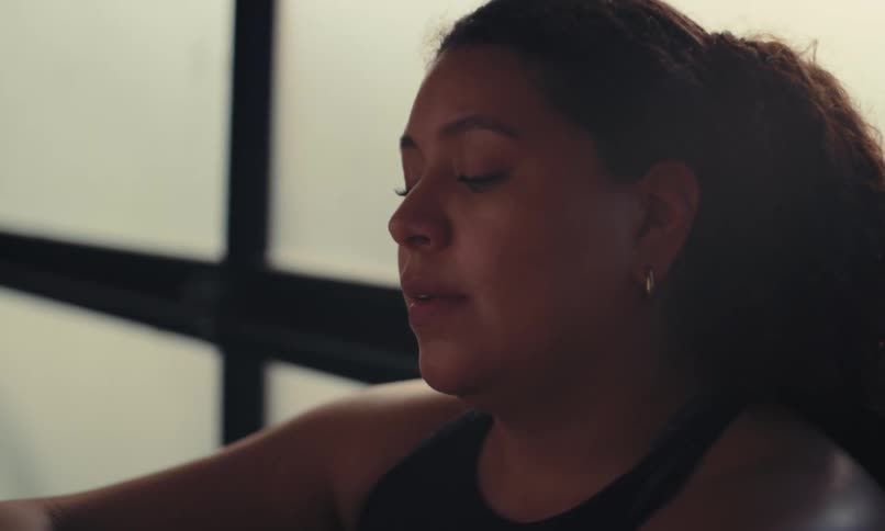 A woman is sweating in the gym and is taking a rest