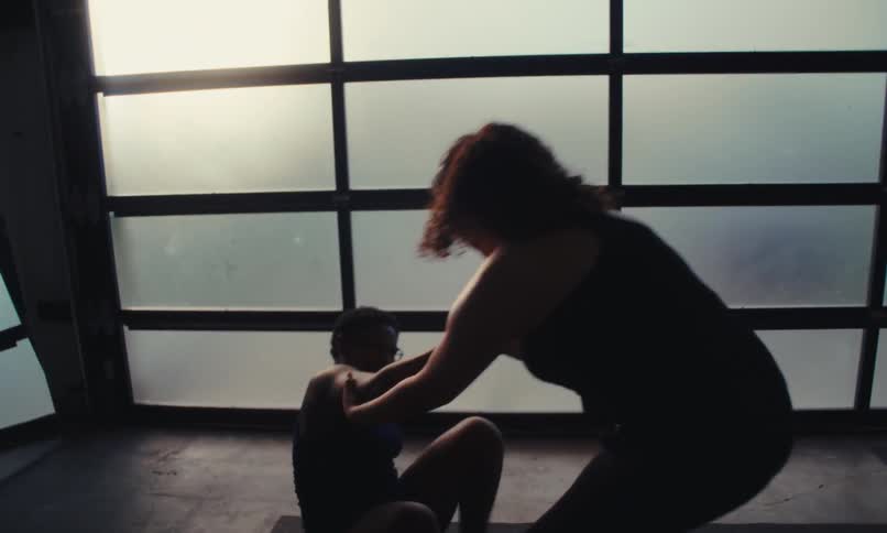 Woman walks into a small gym and helps her friend up