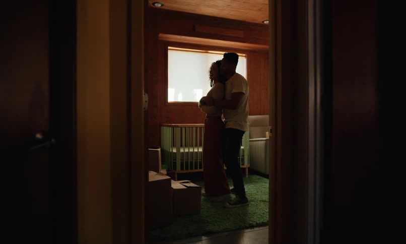 Couple dancing and hugging in a room with a crib