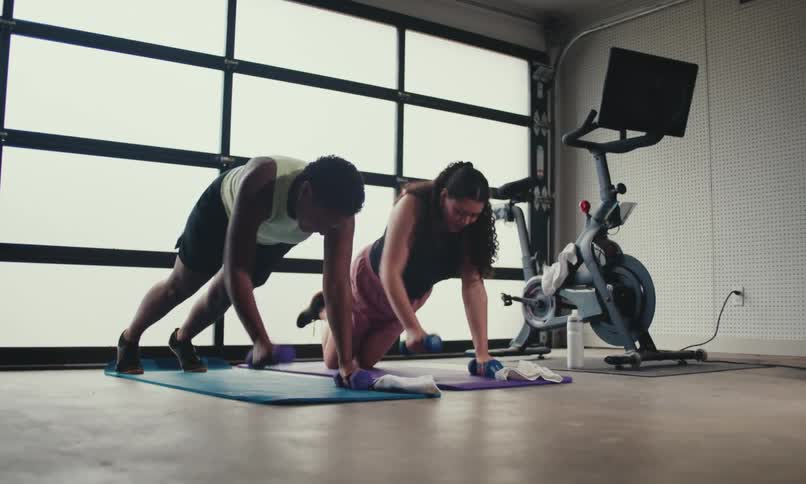 Two women fist bump after working out