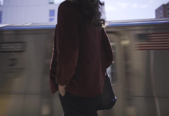 A woman walks by the moving train
