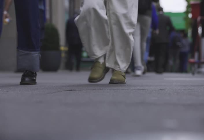 Pedestrians walk along a busy city sidewalk during the daytime