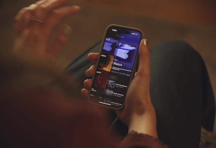 A female hand holds and taps a smartphone