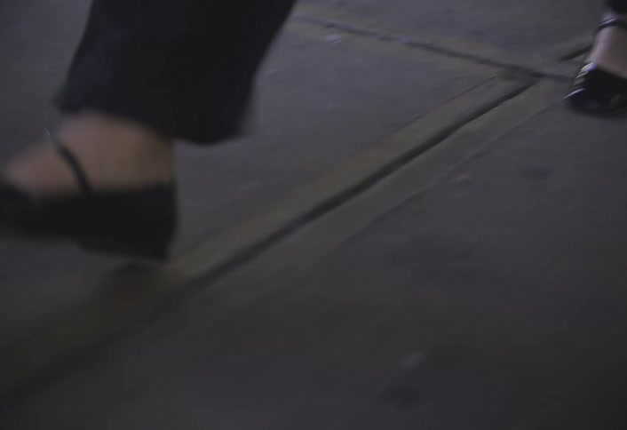 Close up of a womans legs in black shoes walking
