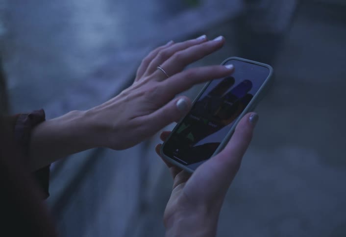 Hands of a woman interacting with a smartphone
