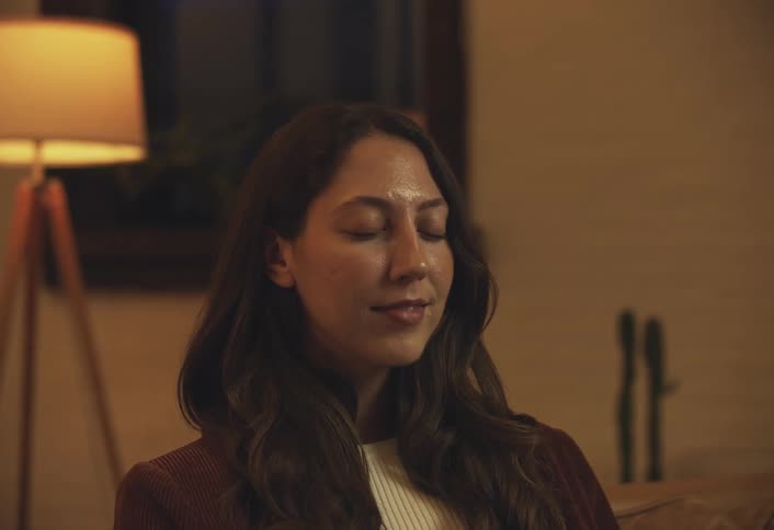 Woman sitting taking a deep breath and closing her eyes