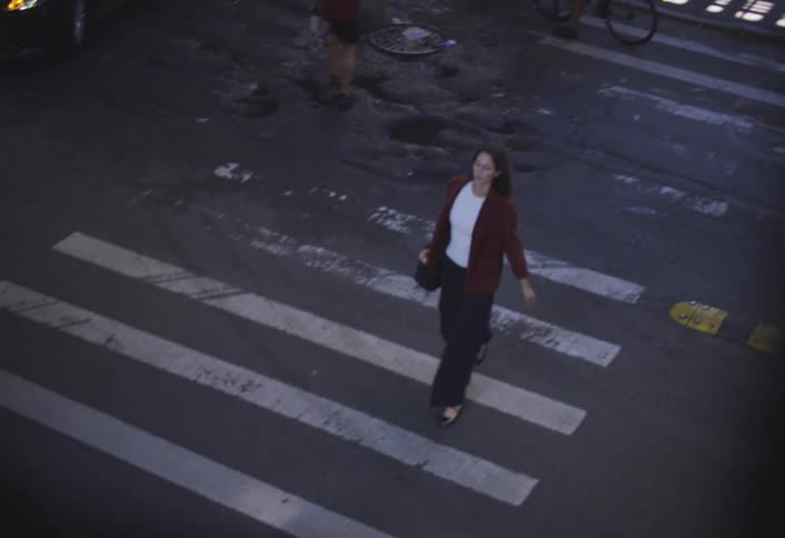 Woman walking across a city crosswalk in daylight