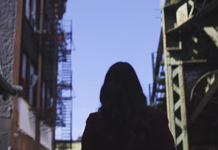 Black haired woman walking through the city