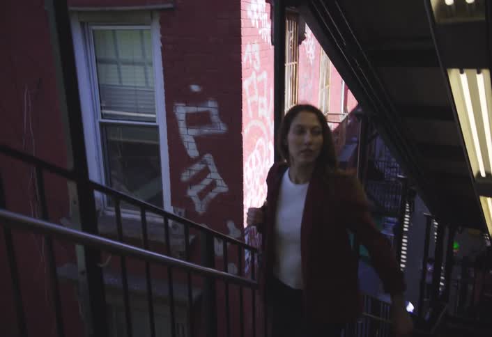 A woman climbs the steps to the train platform