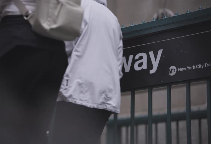 Pedestrians walk past an entrance to the new york city subway during the daytime
