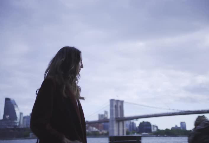 A woman is walking by the water in the city