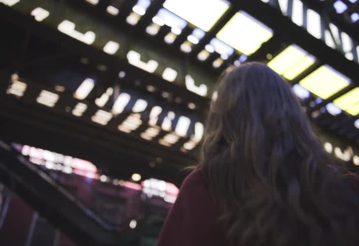 A woman walks towards the staircase to the train platform