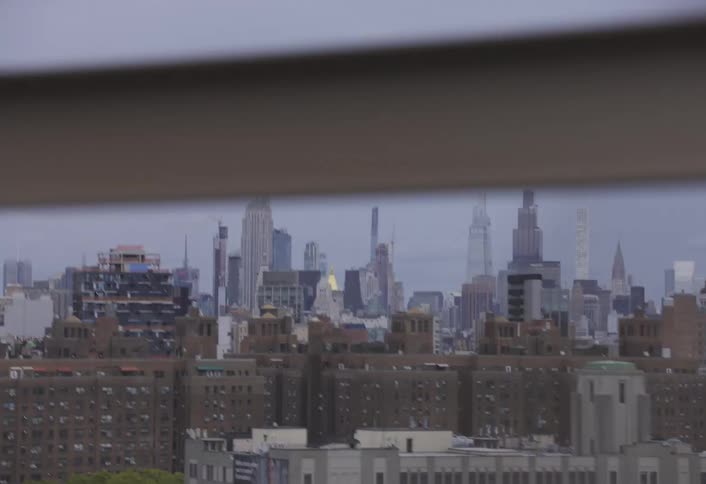 A view of the new york city skyline from a moving vehicle crossing a bridge