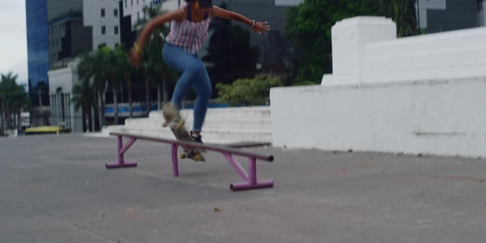 A girl rides on a skateboard in the park