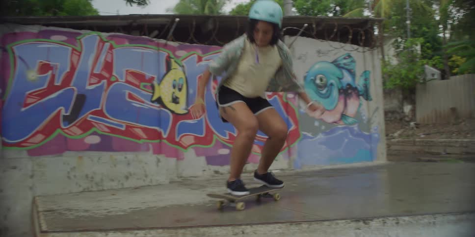 A teenage girl is on a skateboard attempting to do tricks