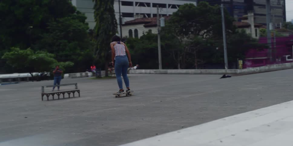 Woman doing skateboarding tricks in an outdoor setting in the city
