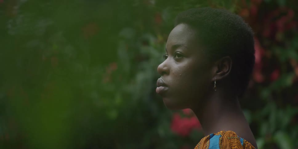 Woman observing her surroundings while standing in an environment surrounded by vegetation