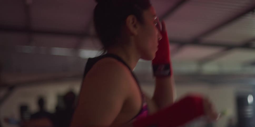 Woman practicing punching movements in a gym