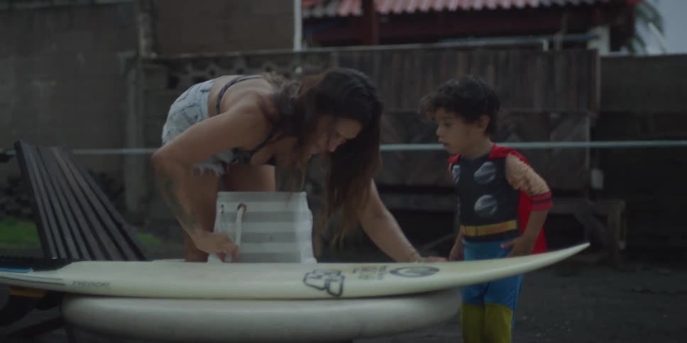 A mother and son are polishing a surfboard