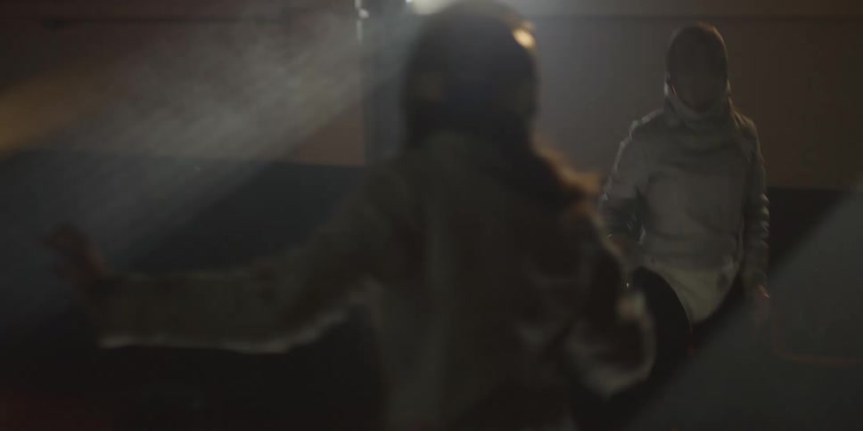 Two girls are fencing each other