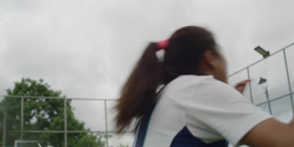 A girl hits the soccer ball with her head