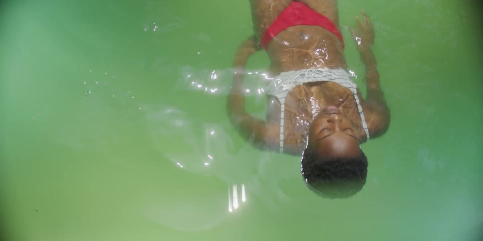 Woman swimming face down in calm greenish waters