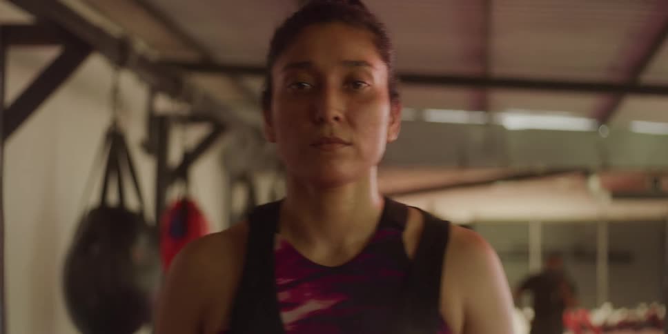 Woman with a serious expression inside a fighting gym