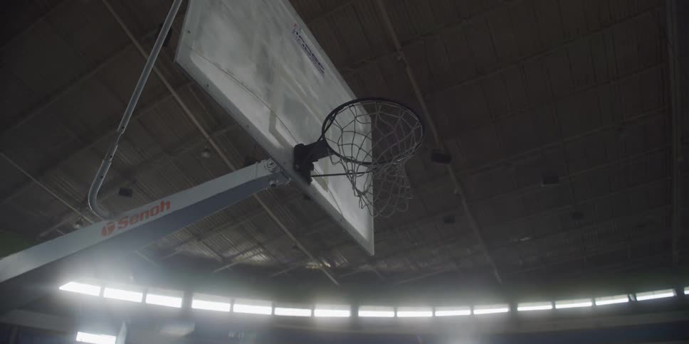 Basketball goes through the hoop during a play in an indoor gym