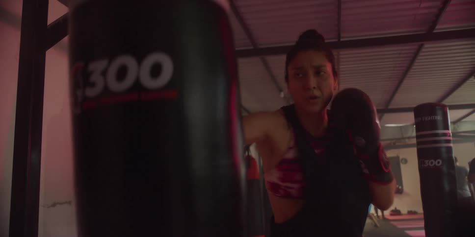 Woman with gloves punching a punching bag