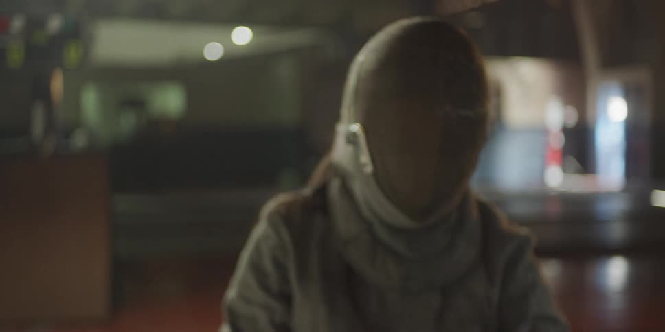 Woman putting on protective helmet and holding fencing sword