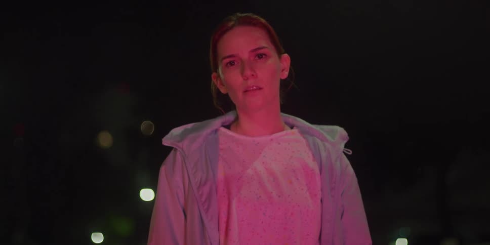 A woman runs up at night