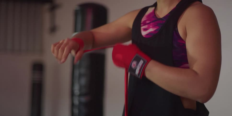Close up of a pair of womans hands wrapping a red ribbon