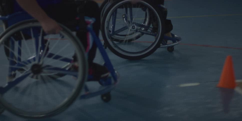 Two women in wheelchairs playing basketball