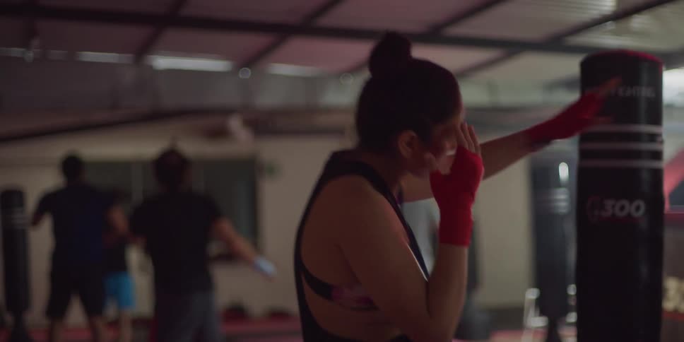 Woman in a martial arts gym stretching her body