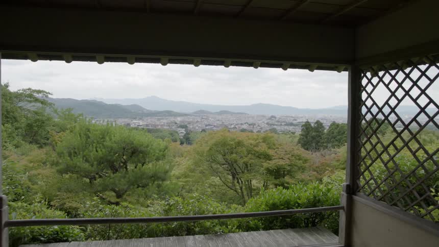 A deck overlooks trees and mountains