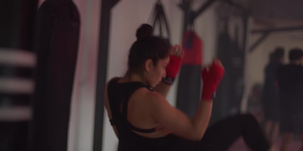 Woman on a mat training punches and kicks