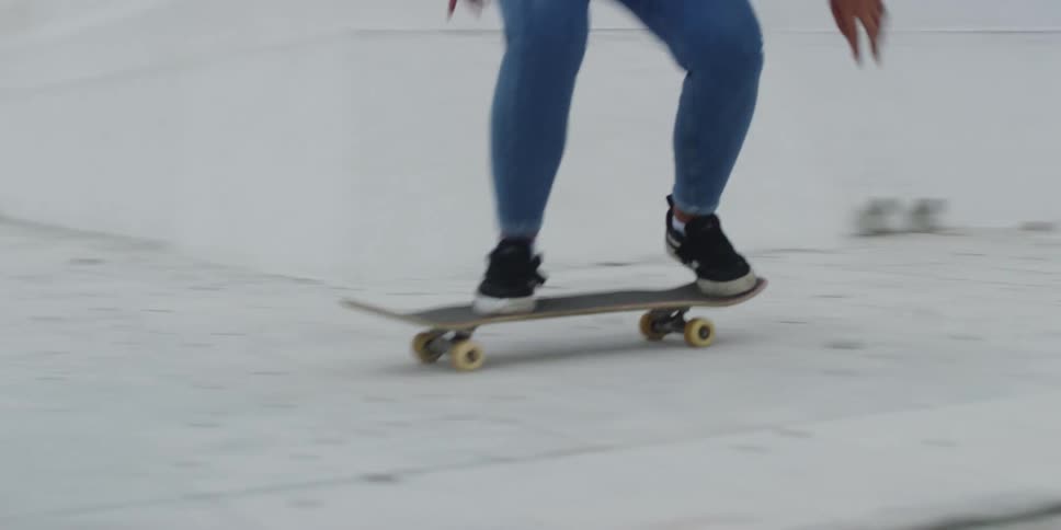 A woman riding a skateboard jumps over a stair and falls to the ground at midday
